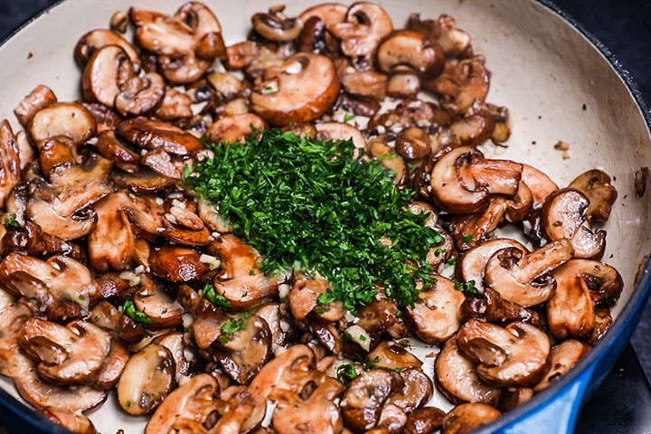 the herbs added to the mushrooms and garlic in the pan
