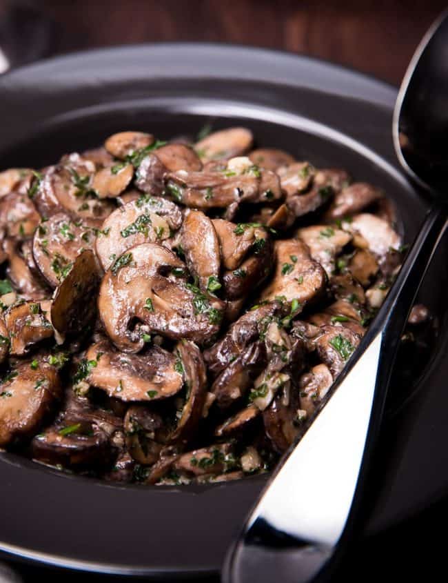 Easy Sautéed Mushrooms in a bowl with a serving spoon