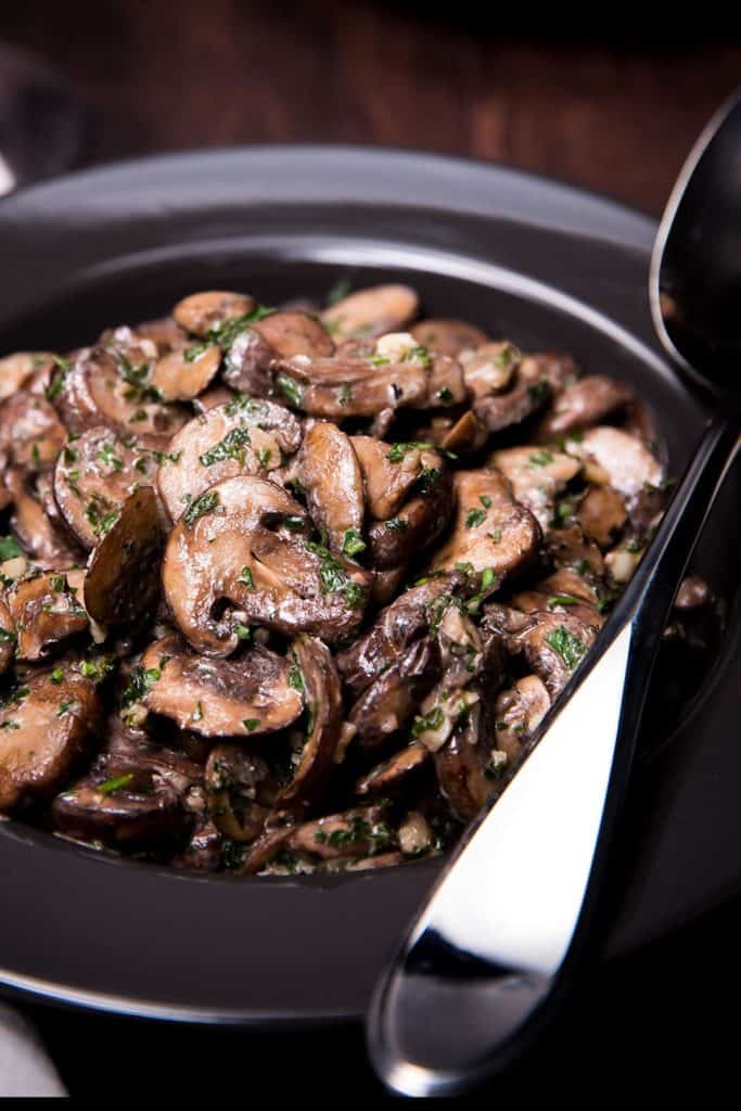 Easy Sautéed Mushrooms in a bowl with a serving spoon