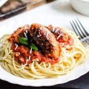 Spaghetti and Italian Sausage with a block of cheese and grater in the background