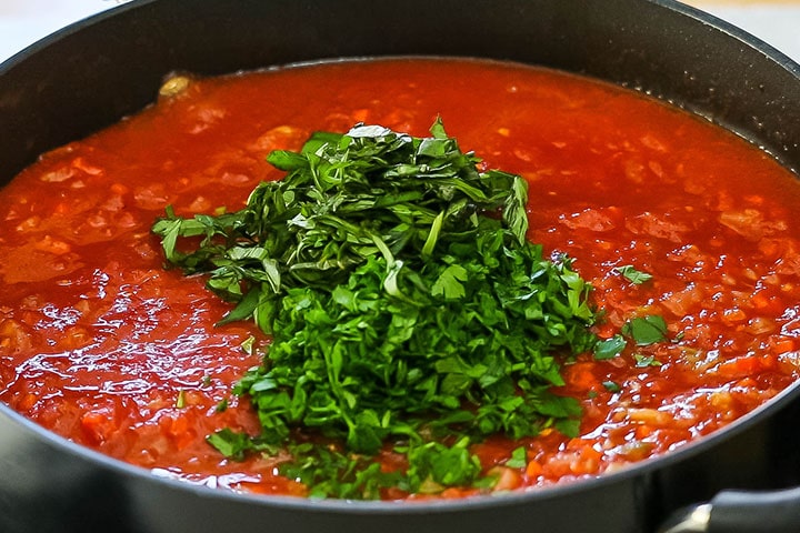 Fresh herbs added to the sauce in the pot