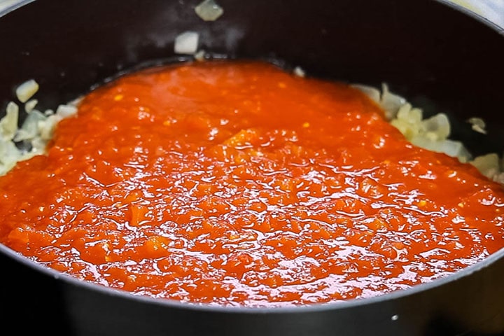 tomatoes added to the pan with the onions and garlic