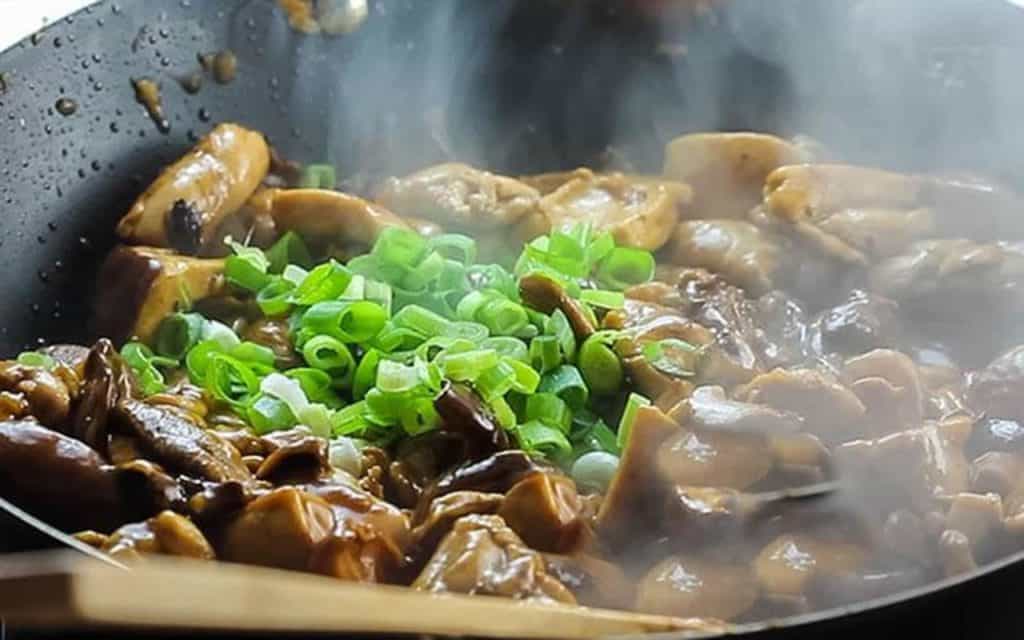 the chicken in the sauce with green onions