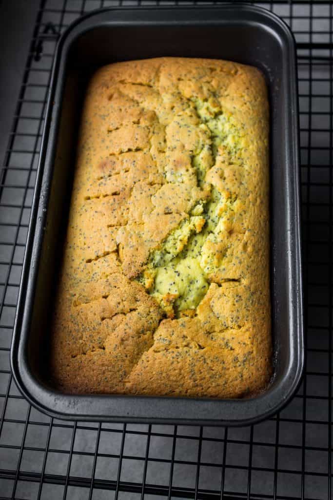 Lemon Drizzle Cake still in the pan with holes in it