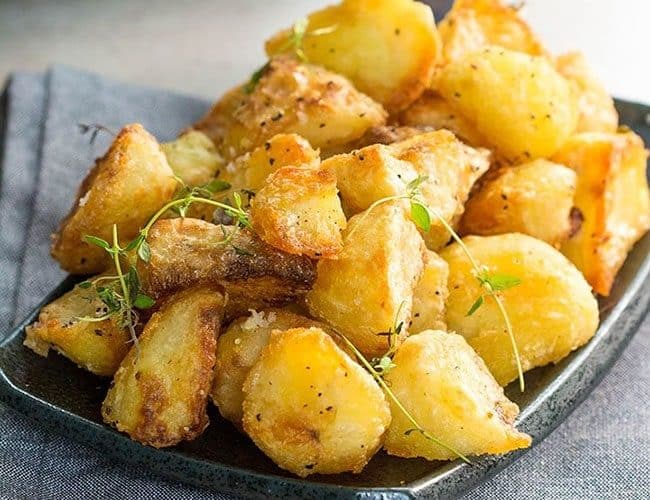 A dish piled high with golden, Crispy Roast Potatoes
