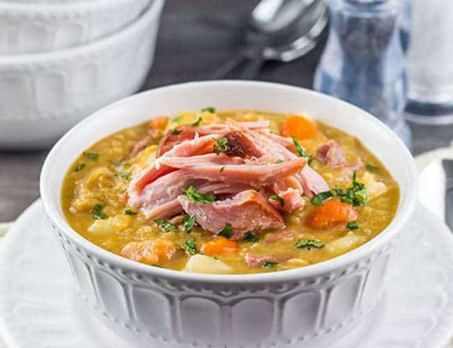 A bowl of vibrant, Split Pea and Ham Soup topped with shredded ham
