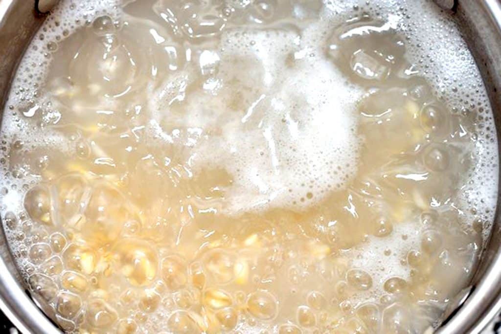Orzo cooking in pot with water