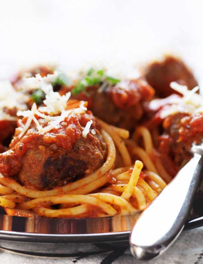 a close up of Spaghetti and Meatballs on a plate with a fork