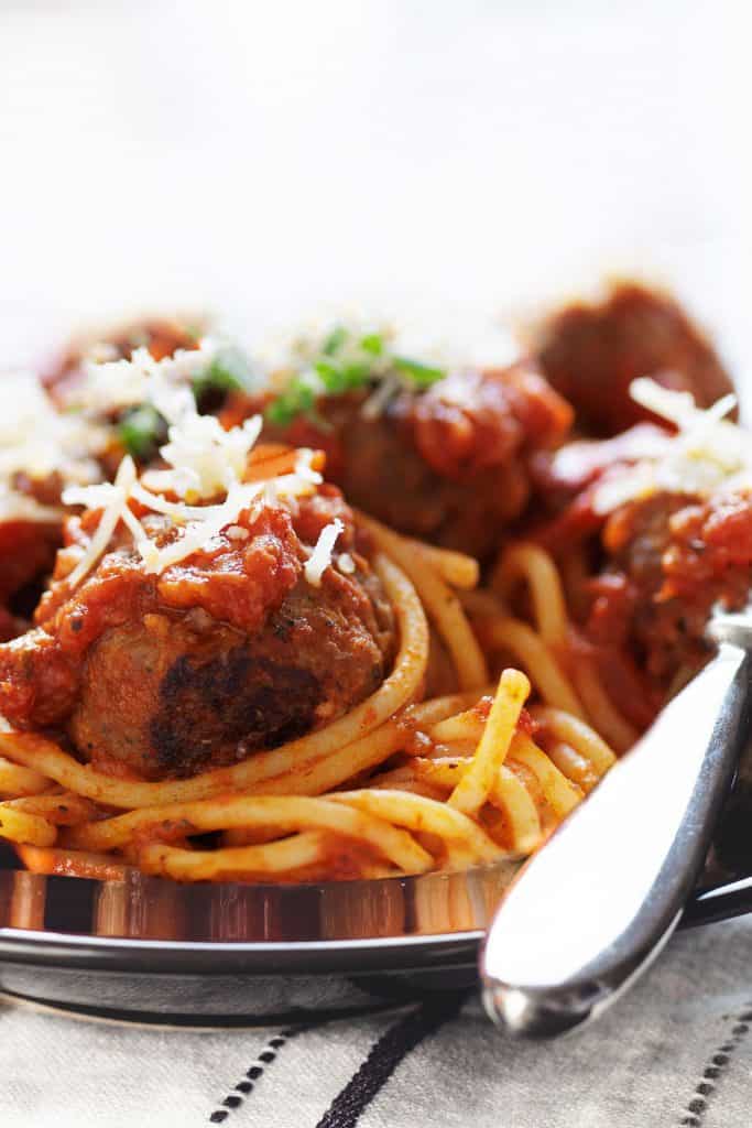 a close up of Spaghetti and Meatballs on a plate with a fork