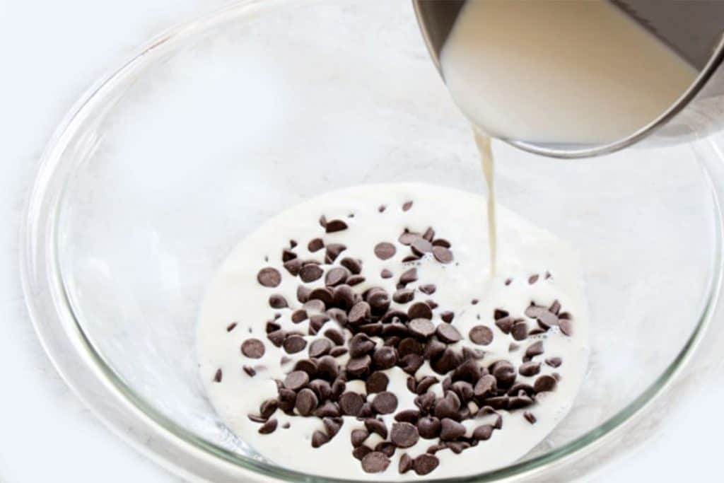 The hot cream being poured over the chocolate