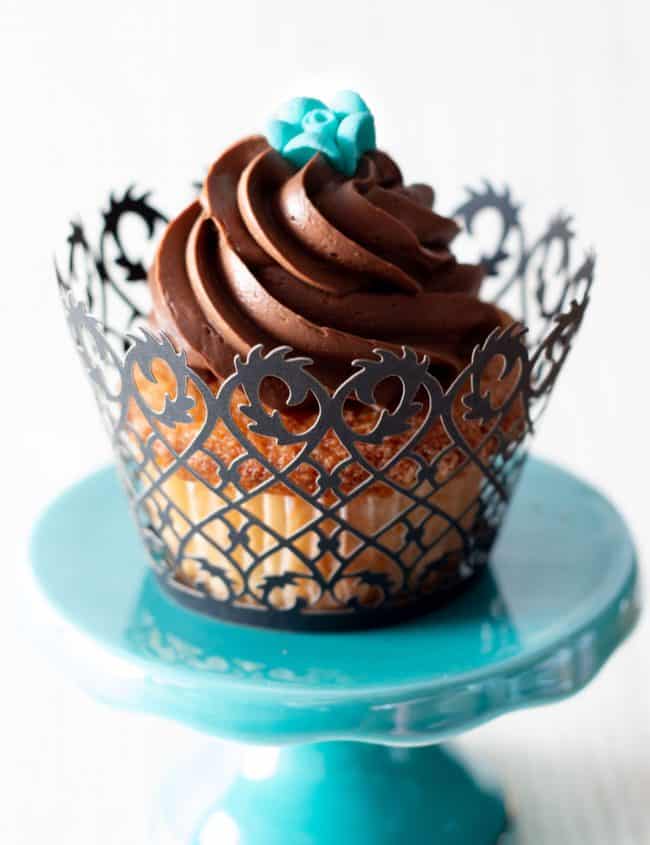 a cupcake swirled with chocolate frosting topped with a little blue rose