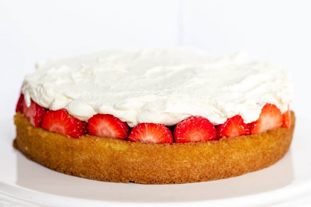 the layer of Lemon Sponge Cake covered with a lyer of strawberries and a layer of whipped cream