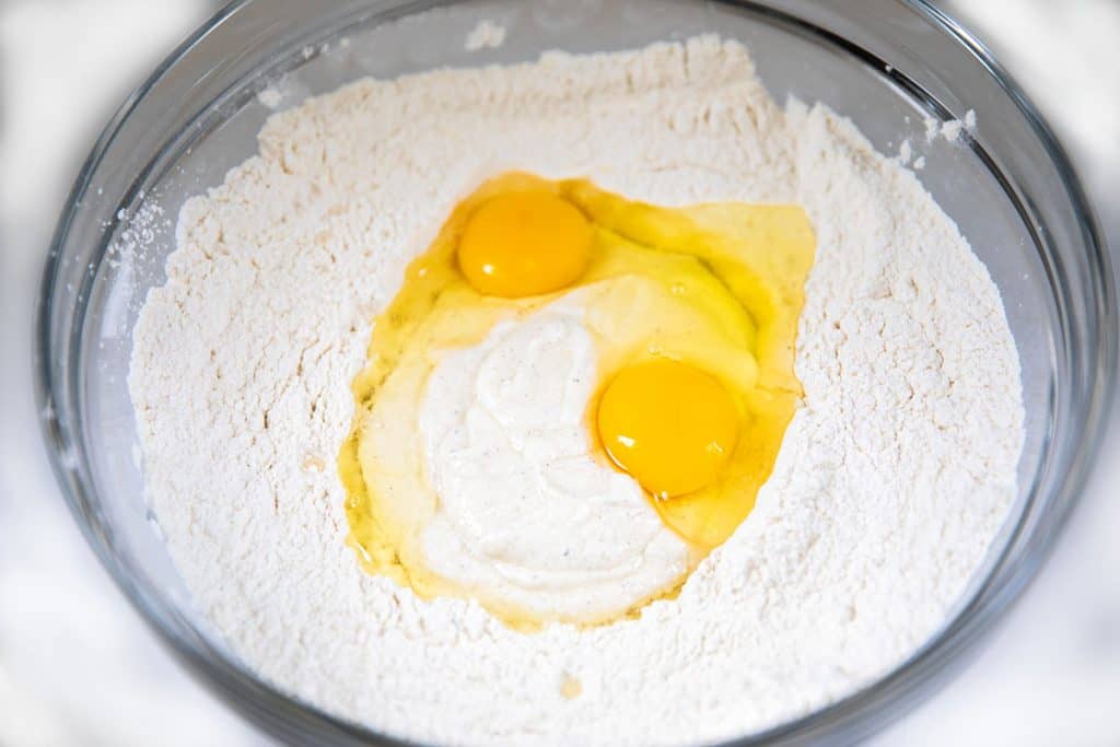 the sour cream mixture and eggs added to the dry ingredients in a bowl 