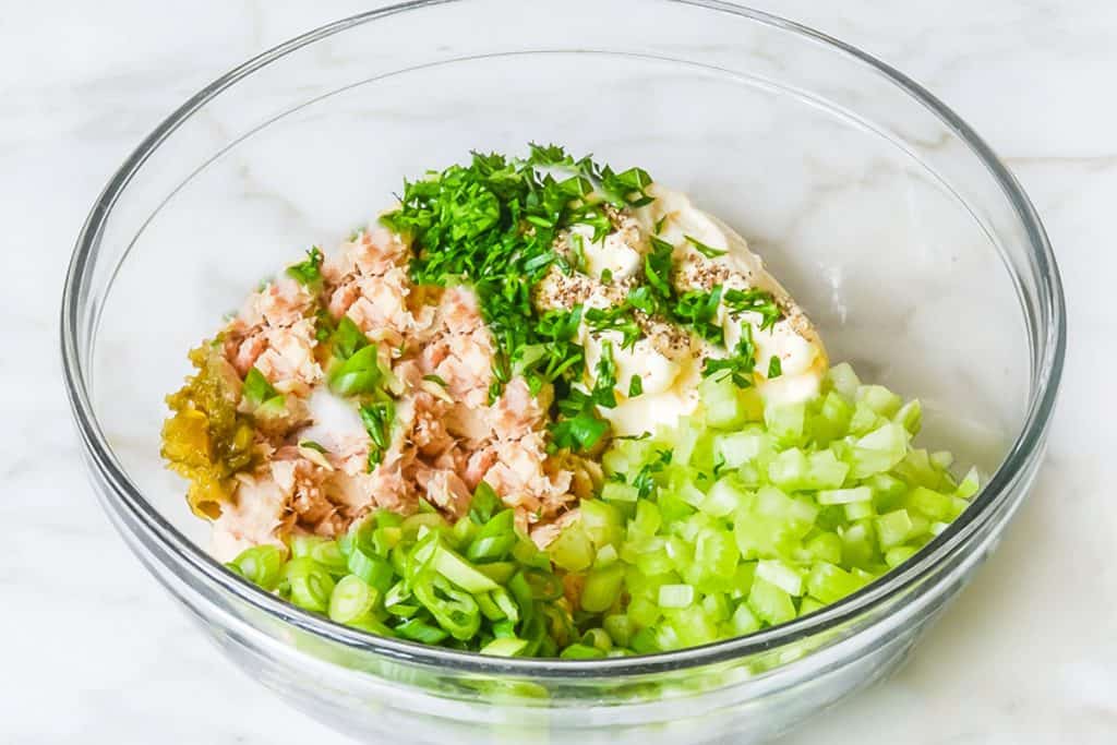 all of the ingredients for the tuna salad in a glass bowl