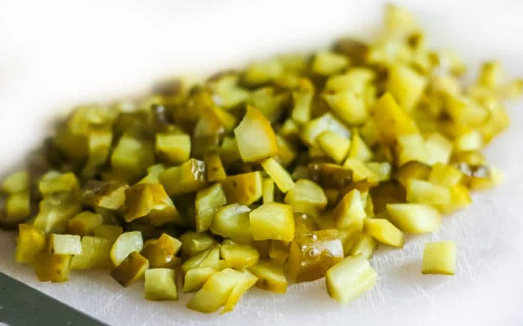 a chopped pickle on a cutting board with a knife