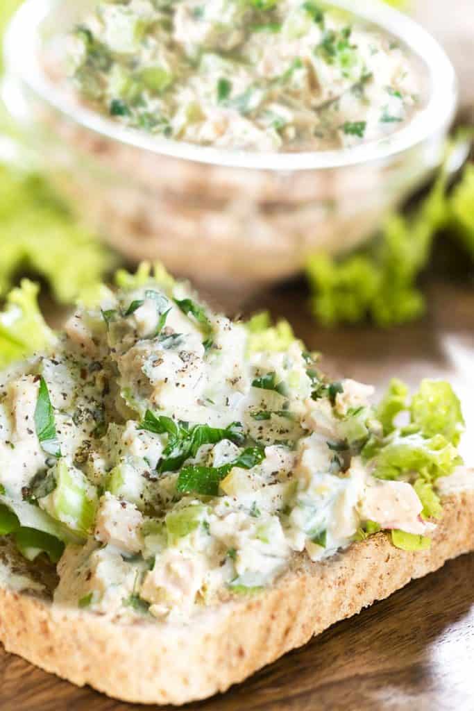 Tuna salad piled high on a piece of wheat bread.