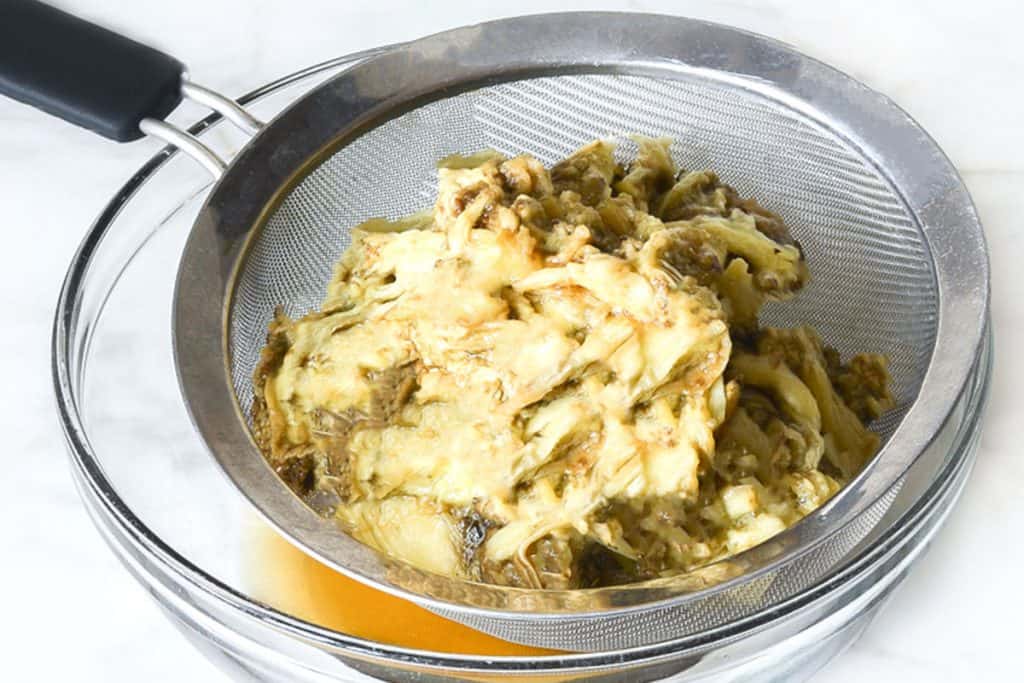 eggplant flesh in a strainer over a bowl
