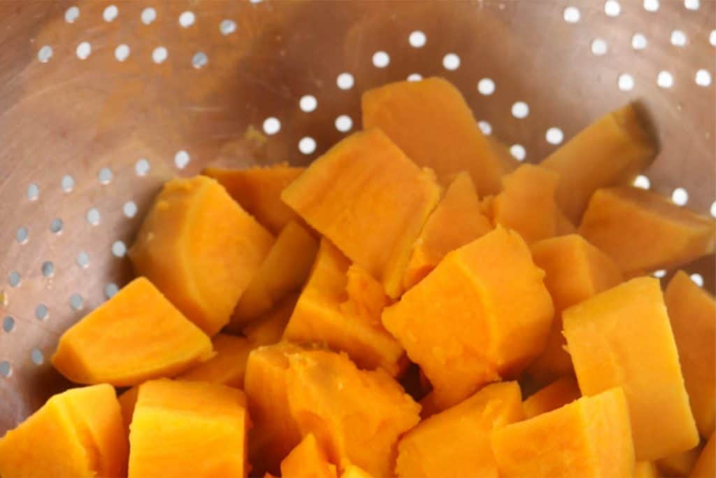 drained sweet potatoes sitting in a strainer