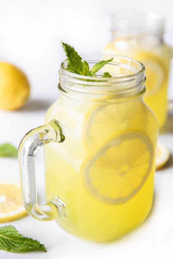 a glass of home lemonade with lemon slices and fresh mint as garnish