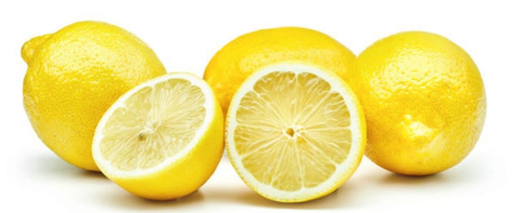 4 lemons on a white table with one cut open to show the inside