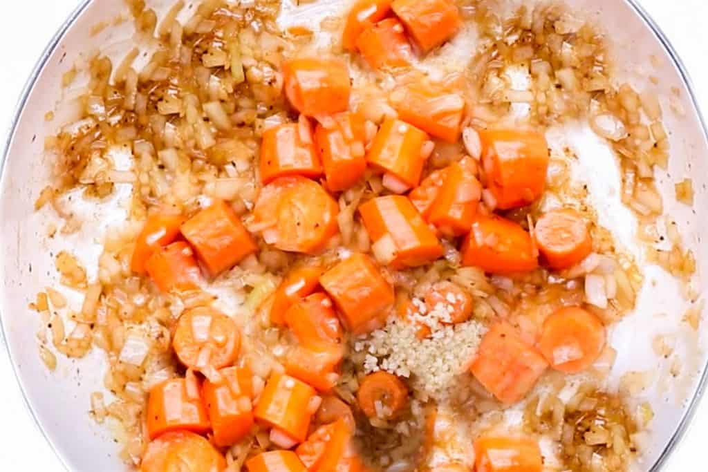 onions, carrots andgarlic cooking in a pan