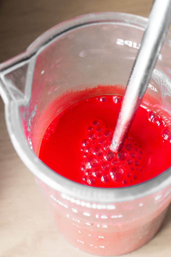 a jug of the wet ingredients mixed with the red food coloring