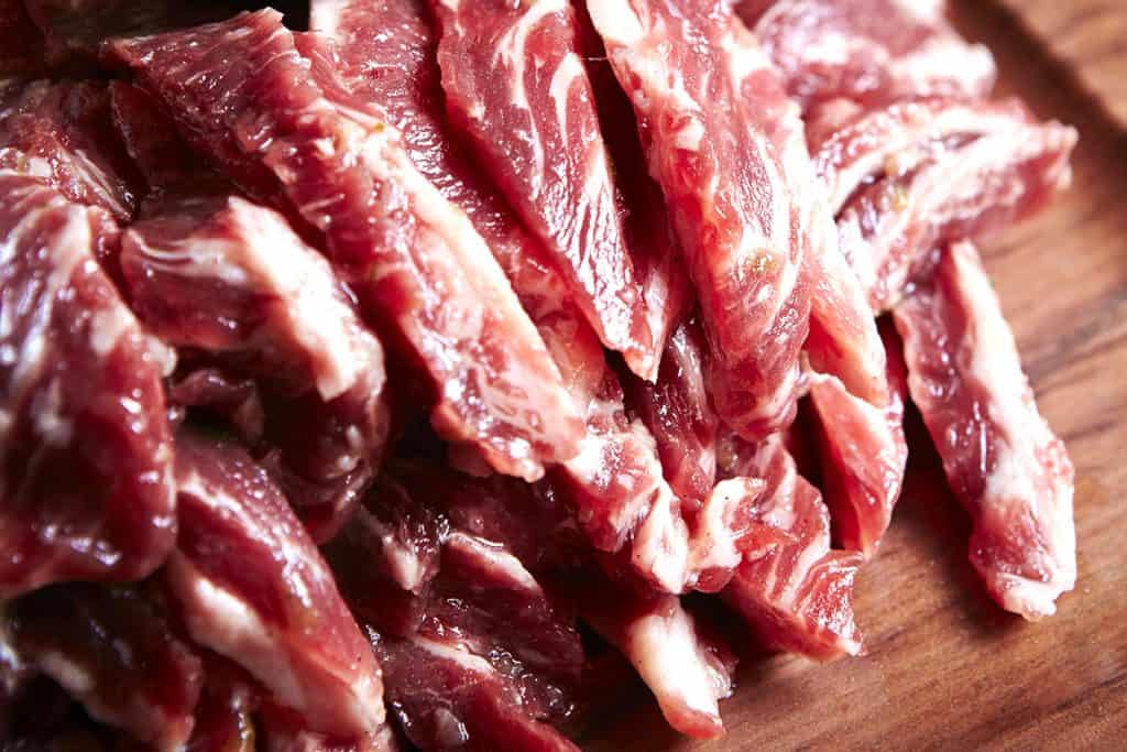 beef cut into strips on a cutting board