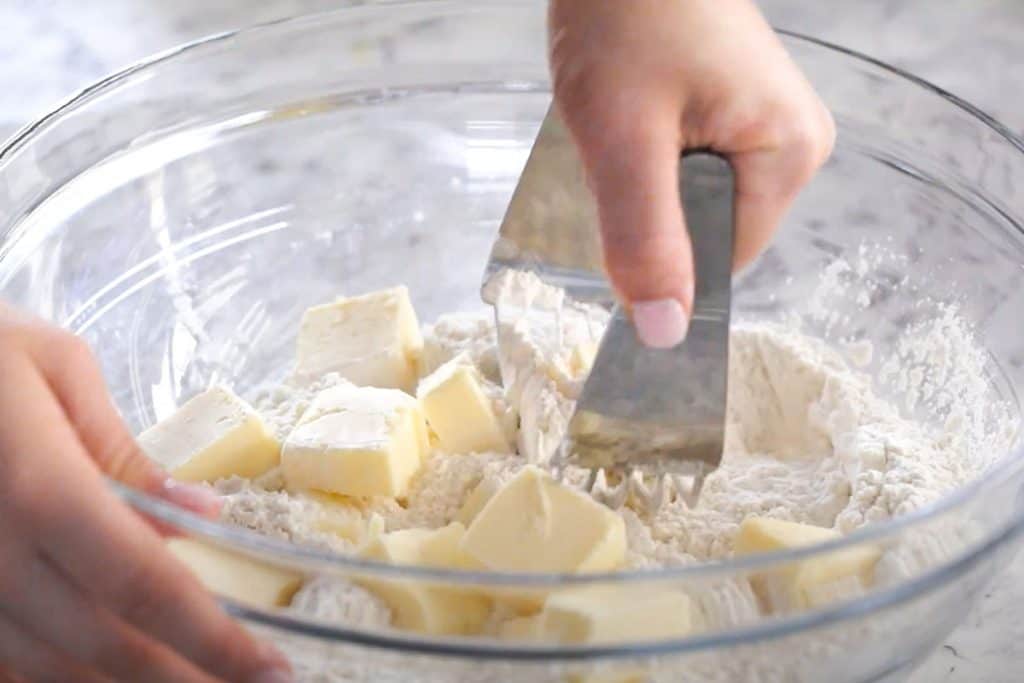 a pastry cutter working butter into flour.