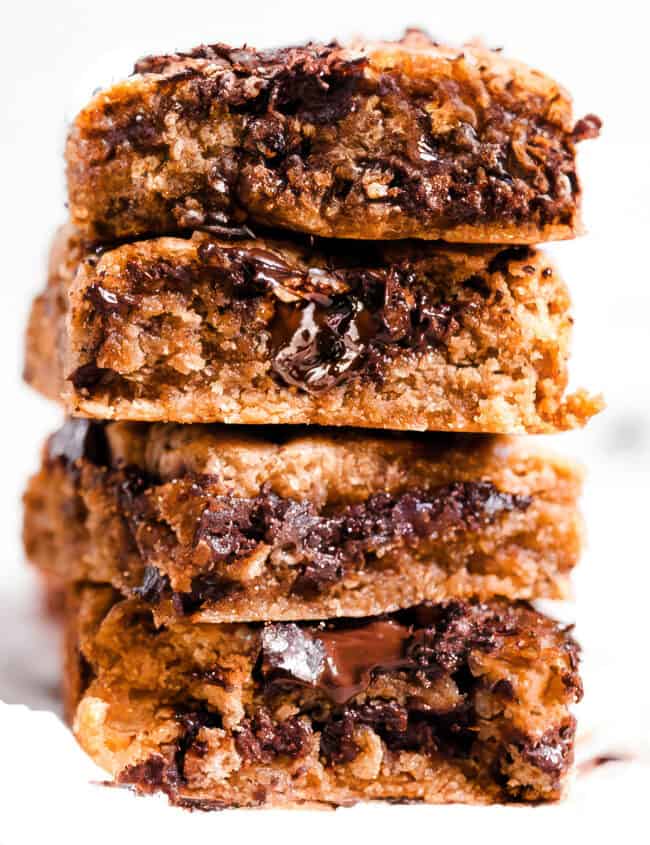 a stack of chocolate chip blondies with melted chocolate chips throughout.