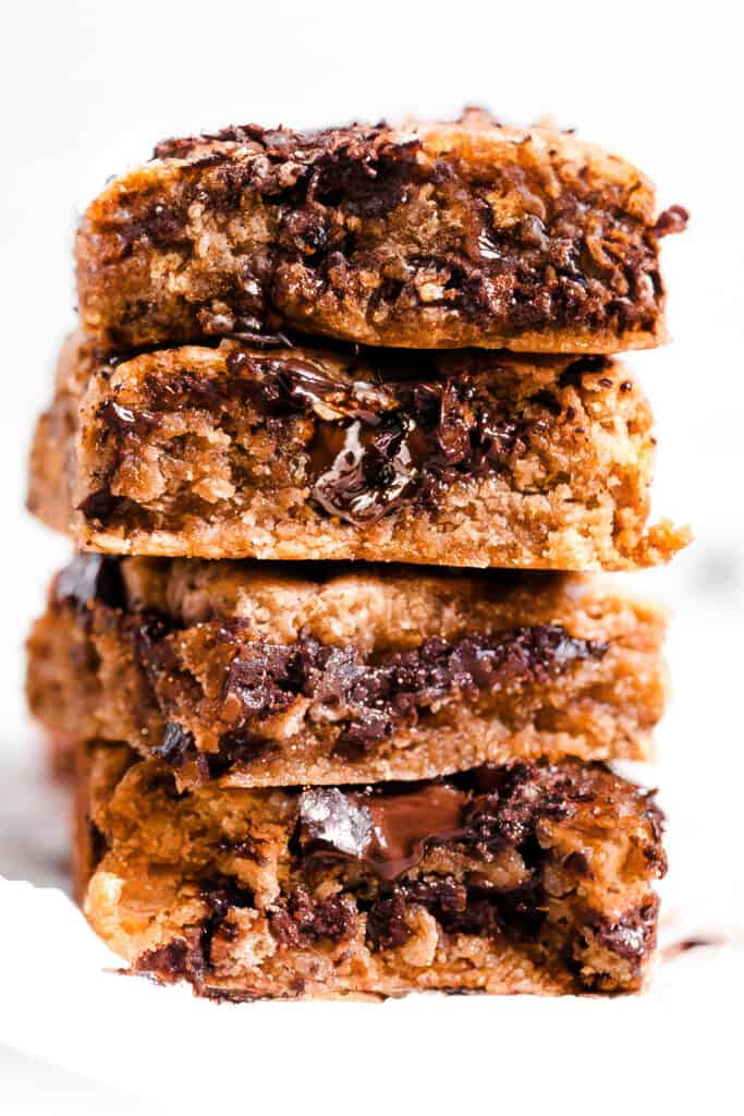 a stack of chocolate chip blondies with melted chocolate chips throughout. 