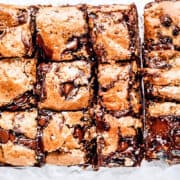 a close up image of freshly baked chocolate chip blondies that are sliced into bars and ready to serve.