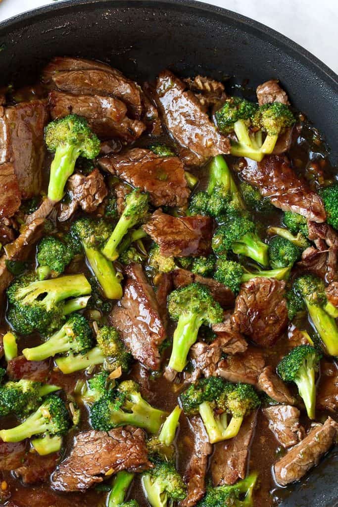 a pan full of beef and broccoli with a brown sauce
