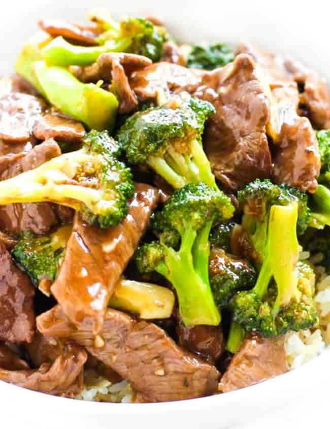 a plate of beef and broccoli with a brown sauce