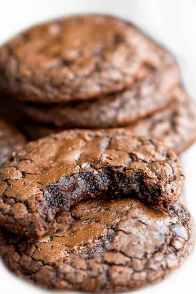 Chocolate cookies stacked on top of eachother with one missing a bite
