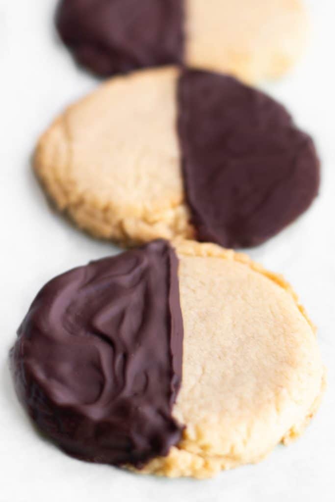 round shortbread cookies with half covered in chocolate