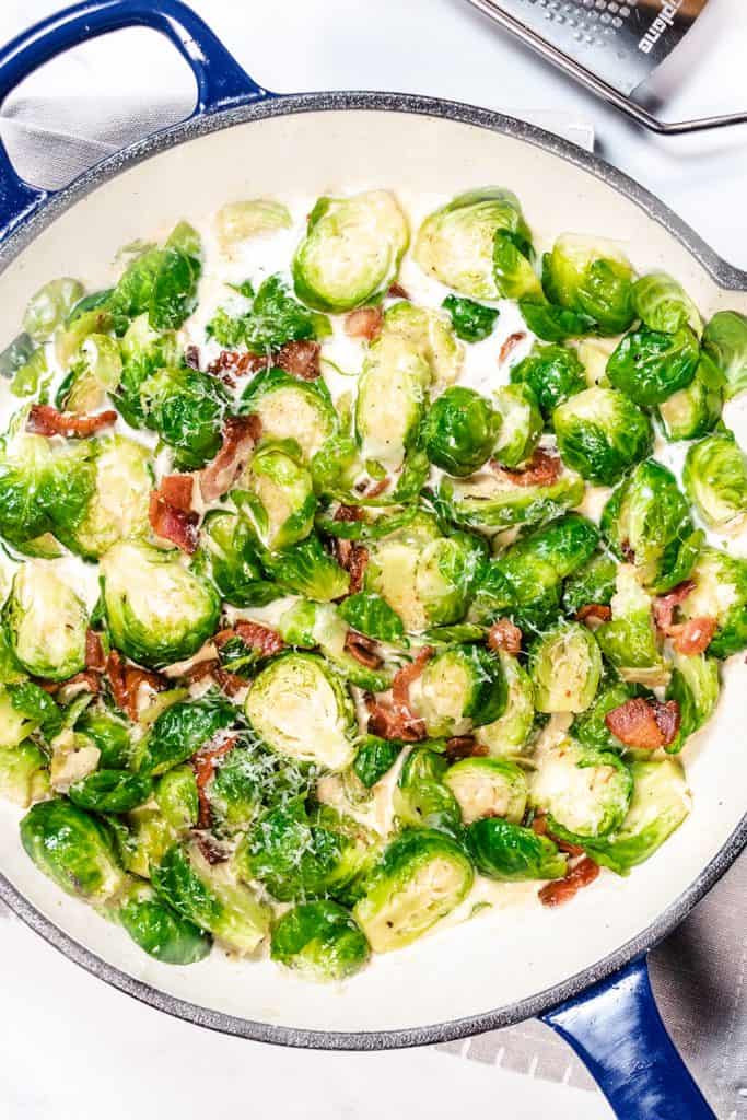 a pan with brussels sprouts amd bacon in a cream sauce