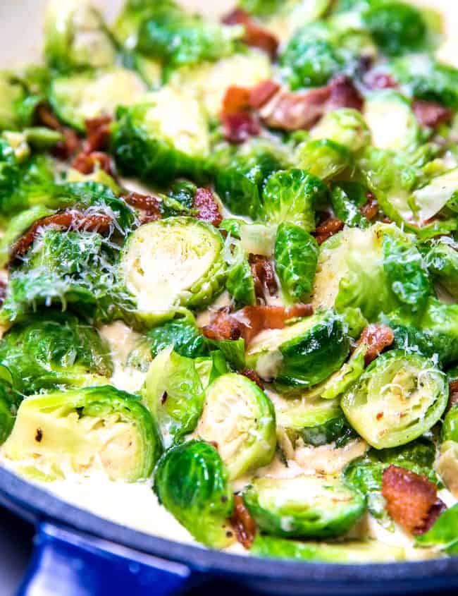 a pan with brussels sprouts amd bacon in a cream sauce