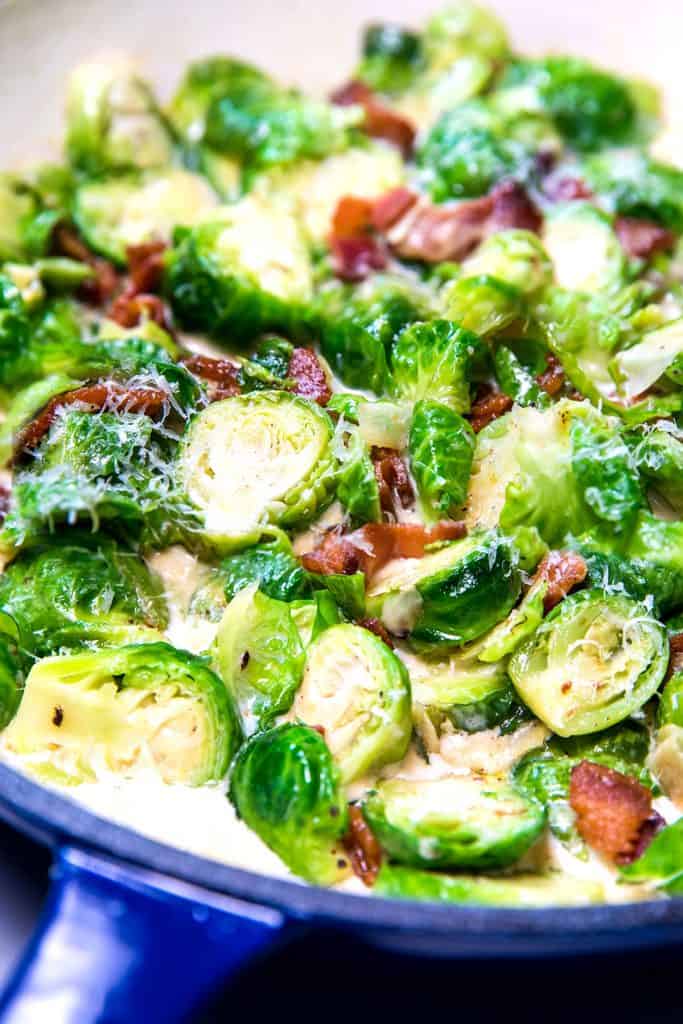 a pan with brussels sprouts amd bacon in a cream sauce