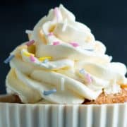 a cupcake topped with a swirl of frosting and sprinkles