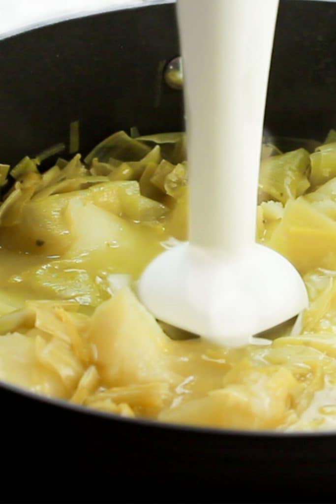 a stick blender in a pan of soup