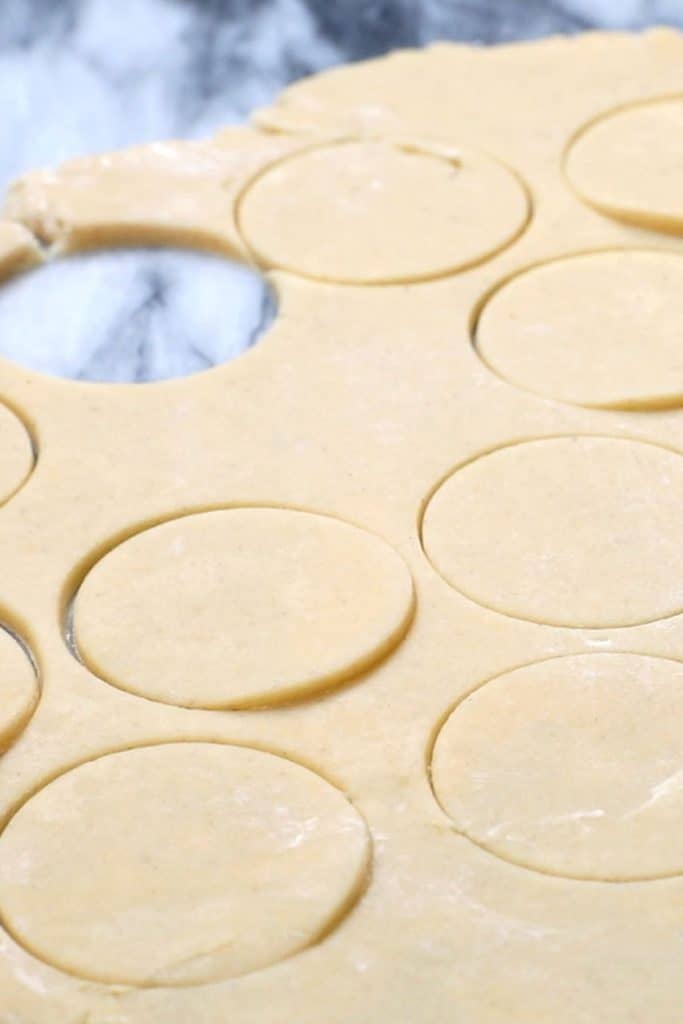 shortbread dough rolled out with rounds cut out of it