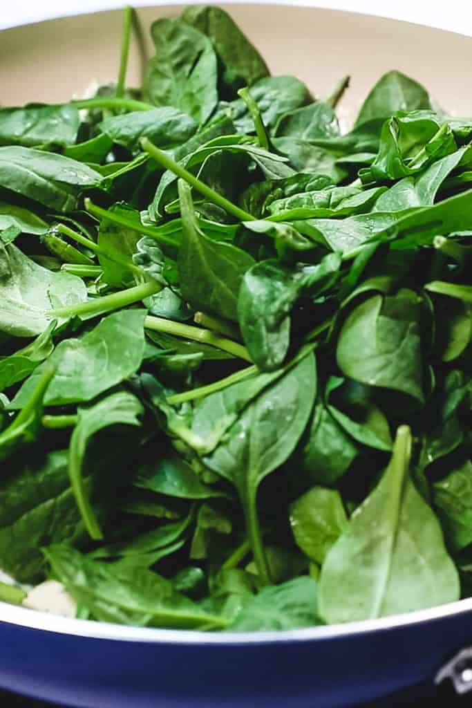 spinach added to cream sauce in pan