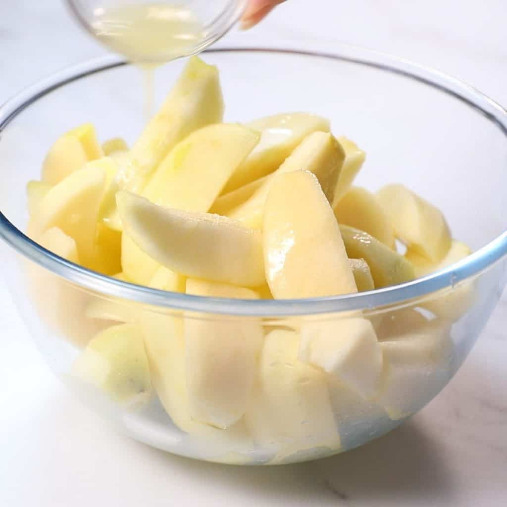 Lemon Juice being poured over sliced apples