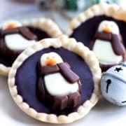 Three chcolate tarts on a plate with christmas decorations