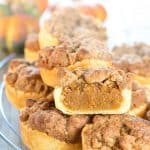 Pumpkin Tarts stacked on a cooling rack with one cut open to show the filling