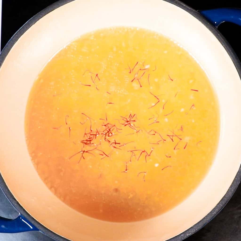 saffron added to stock in a pan