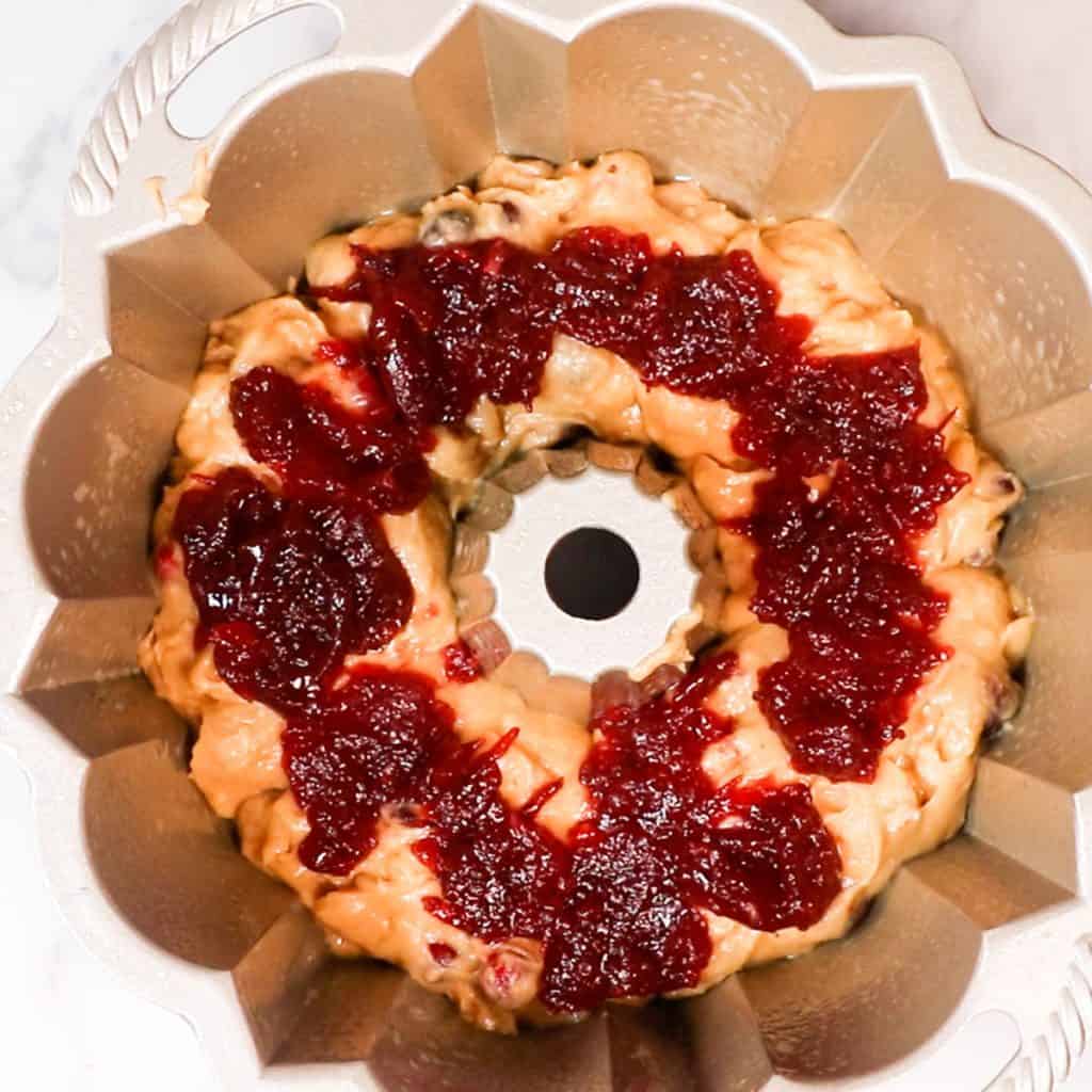 the cranberry sauce spooned onto the batter in the pan.