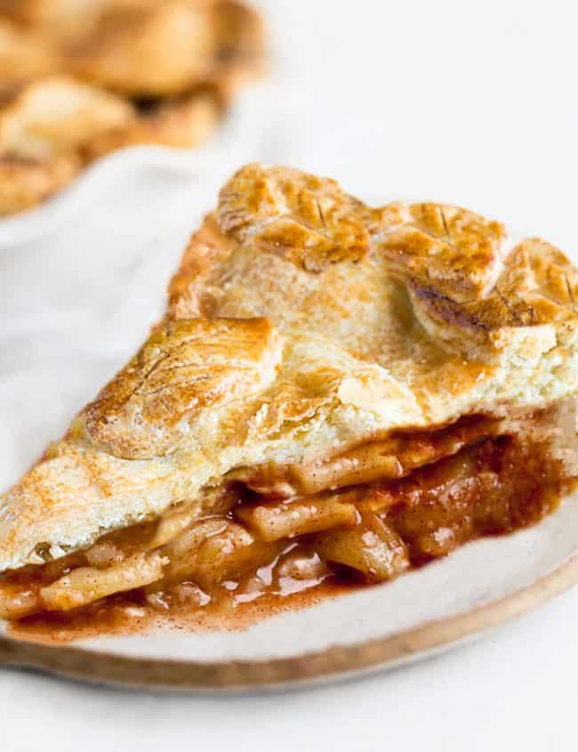 A slice of apple pie with a golen applie pie filling