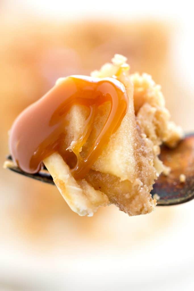 a forkful of apple pie with caramel sauce