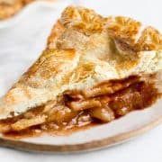 A slice of apple pie with a golen applie pie filling